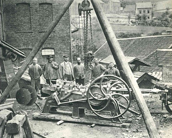 Nietenschlagpresse, 1897 im Eigenbau hergestellt (Wilhelm Berg als dritter von links)